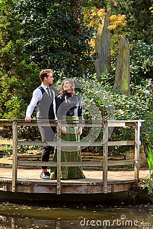 Couple in Victorian fashion near lake in park