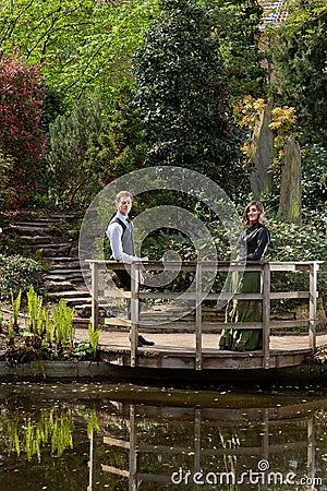 Couple in Victorian fashion near lake in park