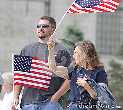 Couple waves American flags at Rally to Secure Our Borders