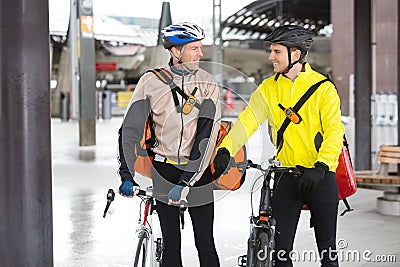 Courier Delivery Men With Bicycles Looking At Each