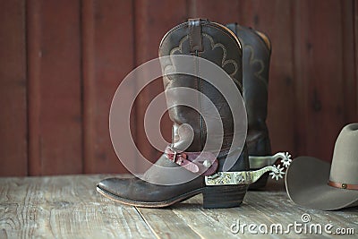 Cowboy boots, spurs and hat on old wood background