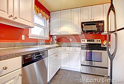 Cozy kitchen room with red wall and white cabinets