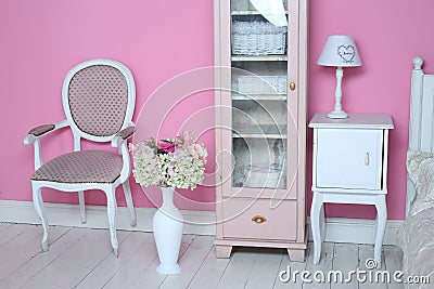 Cozy stylish vintage corner of the pink bedroom with floor vase