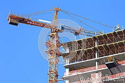 Crane and building under construction against sky.
