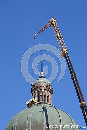 A Crane holding a lift to clean the dome of the building