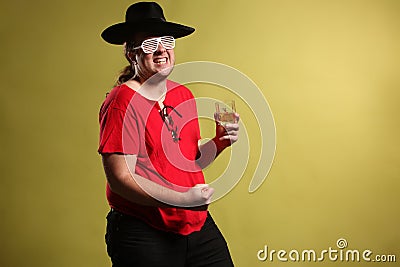 Crazy rock and rollerer with a big black hat, party glasses and a glass of whiskey in front of a cheetah skin background