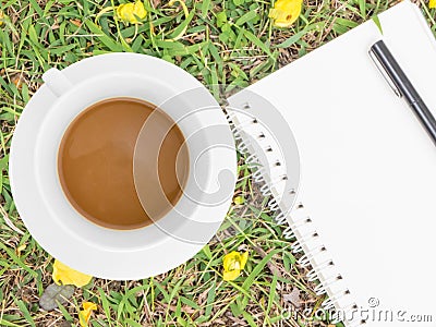 Cream notebook with pen and cup of coffee