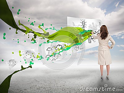Creative businesswoman drawing on a paper next to paint splash