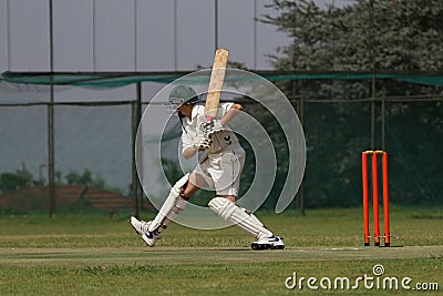 Cricket school boy is attacking the ball