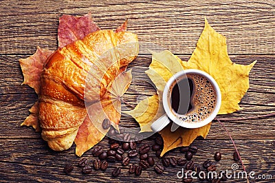 Croissant, coffee and autumn leaves