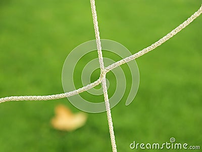 Crossed soccer nets, soccer football in goal net with plastic grass on football playground