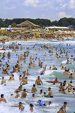 Crowded beach and people in the waves