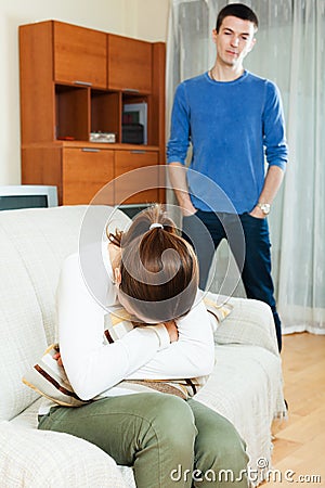 Crying young woman against standing man