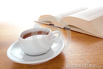 Cup of Coffee and Big Book Leisure on a Wood Table