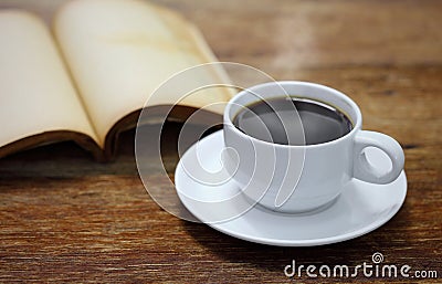 Cup of coffee with book on a wooden
