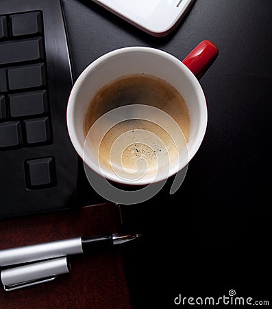 Cup of coffee and business objects on the table