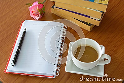 Cup of coffee with notebook and flower