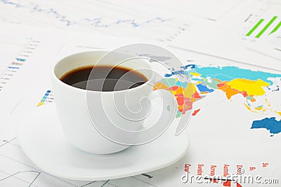 Cup of coffee over world map and financial documents