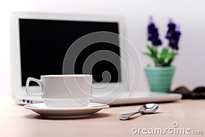 Cup of coffee place in front of Laptop