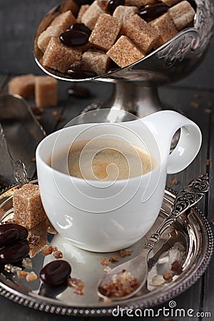 Cup of coffee, sugar cubes and chocolate candy on old wooden background