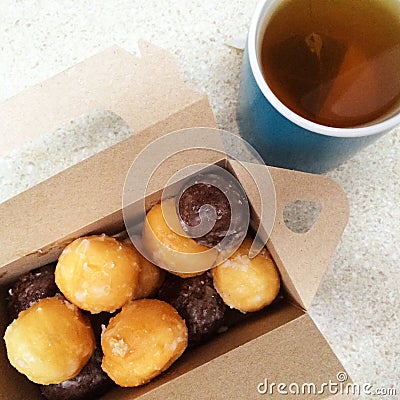 Cup of tea and box of sweet doughnuts