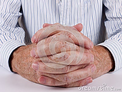 Customer service man at desk, hands clasped