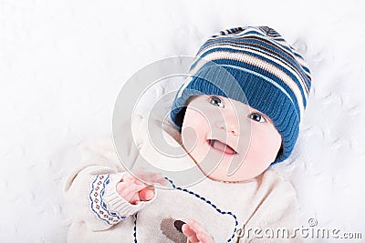 Cute baby in a knitted sweater and blue hat