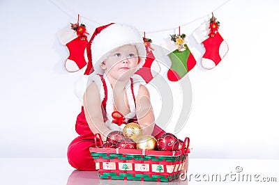 Cute baby Santa Claus with toys.