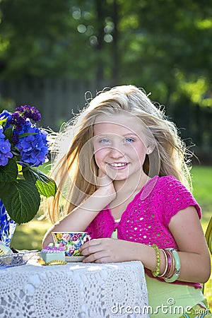 Cute blonde girl at outdoor tea party