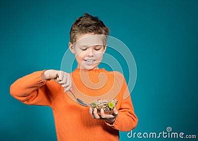 Cute boy eating cereals isolated on blue background