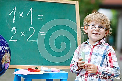 Cute child at blackboard practicing mathematics
