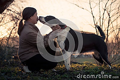 Cute dog kissing his mistress, outdoors