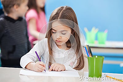 Cute Girl Drawing With Sketch Pen In Classroom