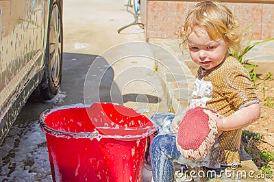 Small girl washing car