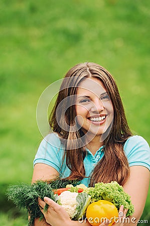 Cute happy woman with organic healthy fruits and vegetables on t
