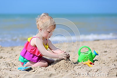 Cute little girl plays on the beach