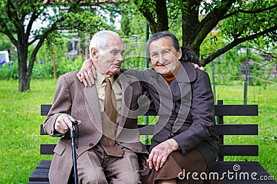 Cute 80 plus year old married couple posing for a portrait in their garden. Love forever concept