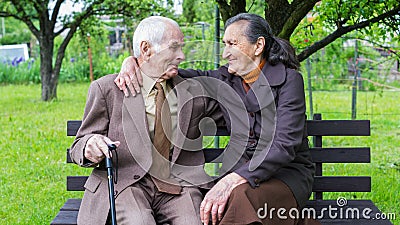 Cute 80 plus year old married couple posing for a portrait in their garden. Love forever concept