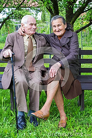 Cute 80 plus year old married couple posing for a portrait in their garden. Love forever concept.