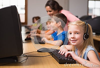 Cute pupils in computer class with teacher