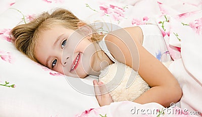 Cute smiling little girl waked up in her bed