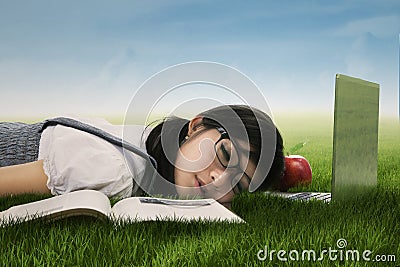 Cute student sleeping on the grass