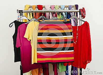 Cute summer outfits displayed on a rack. Striped skirt with matching blouses.