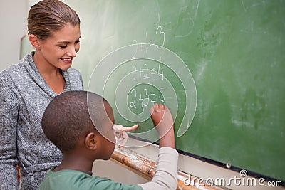 Cute teacher and a pupil making an addition