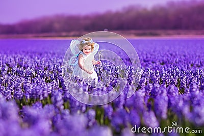 Cute toddlger girl in fairy costume playing with p