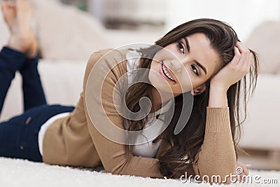 Cute woman lying down on carpet