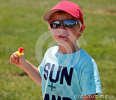 Cute young boy with dirty shirt and a ringpop