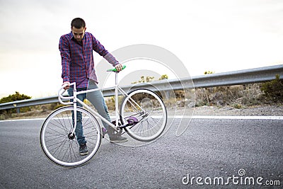 Cyclist man riding fixed gear sport bike in sunny day