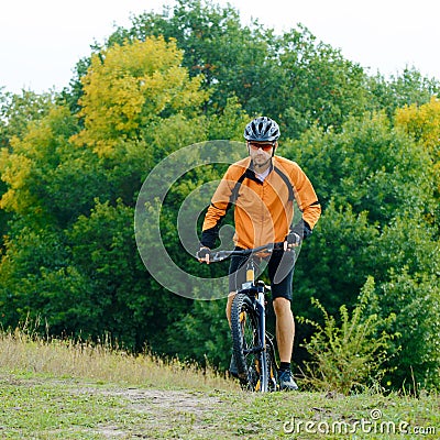 Cyclist Riding the Bike in the Beautiful Autumn Forest