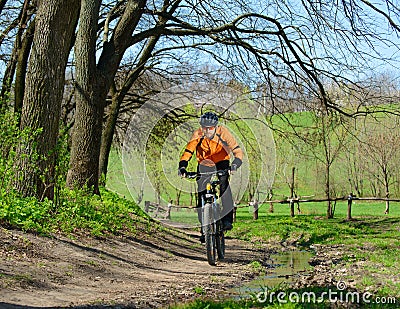 Cyclist Riding the Bike on the Trail in the Forest